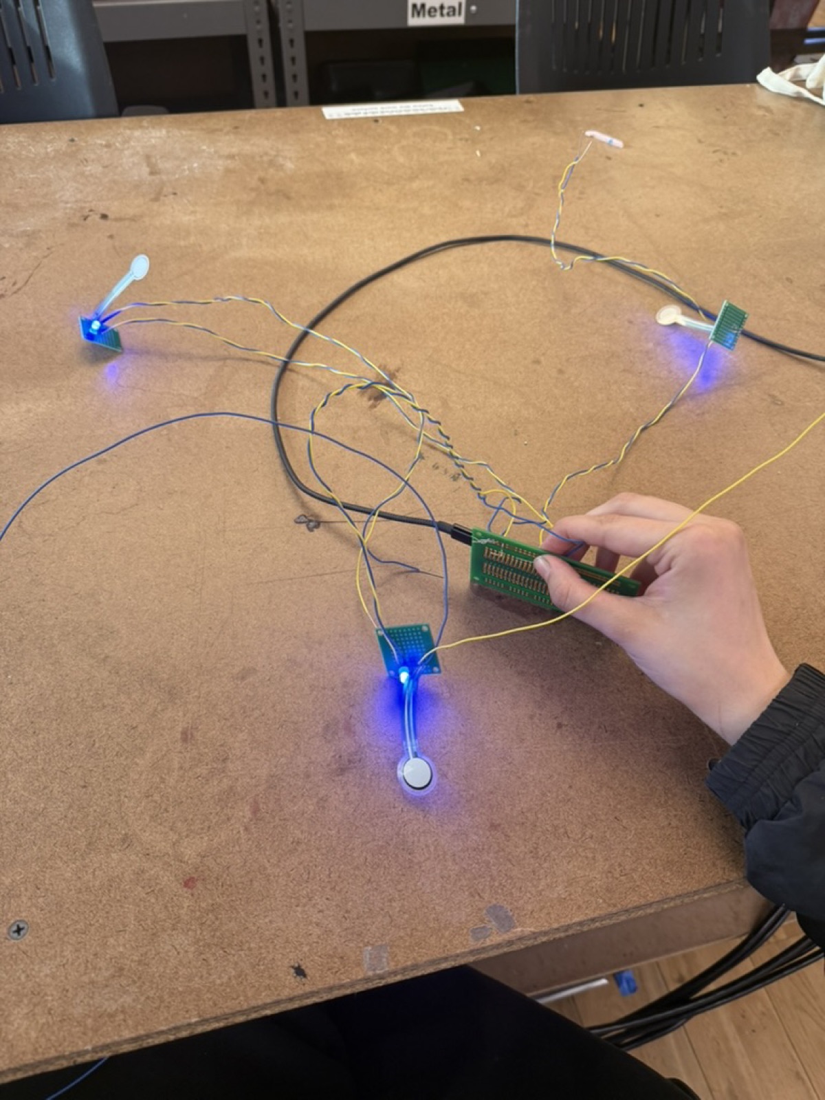 Four individual pressure-sensor pads with blue LEDs, wired together on the workbench